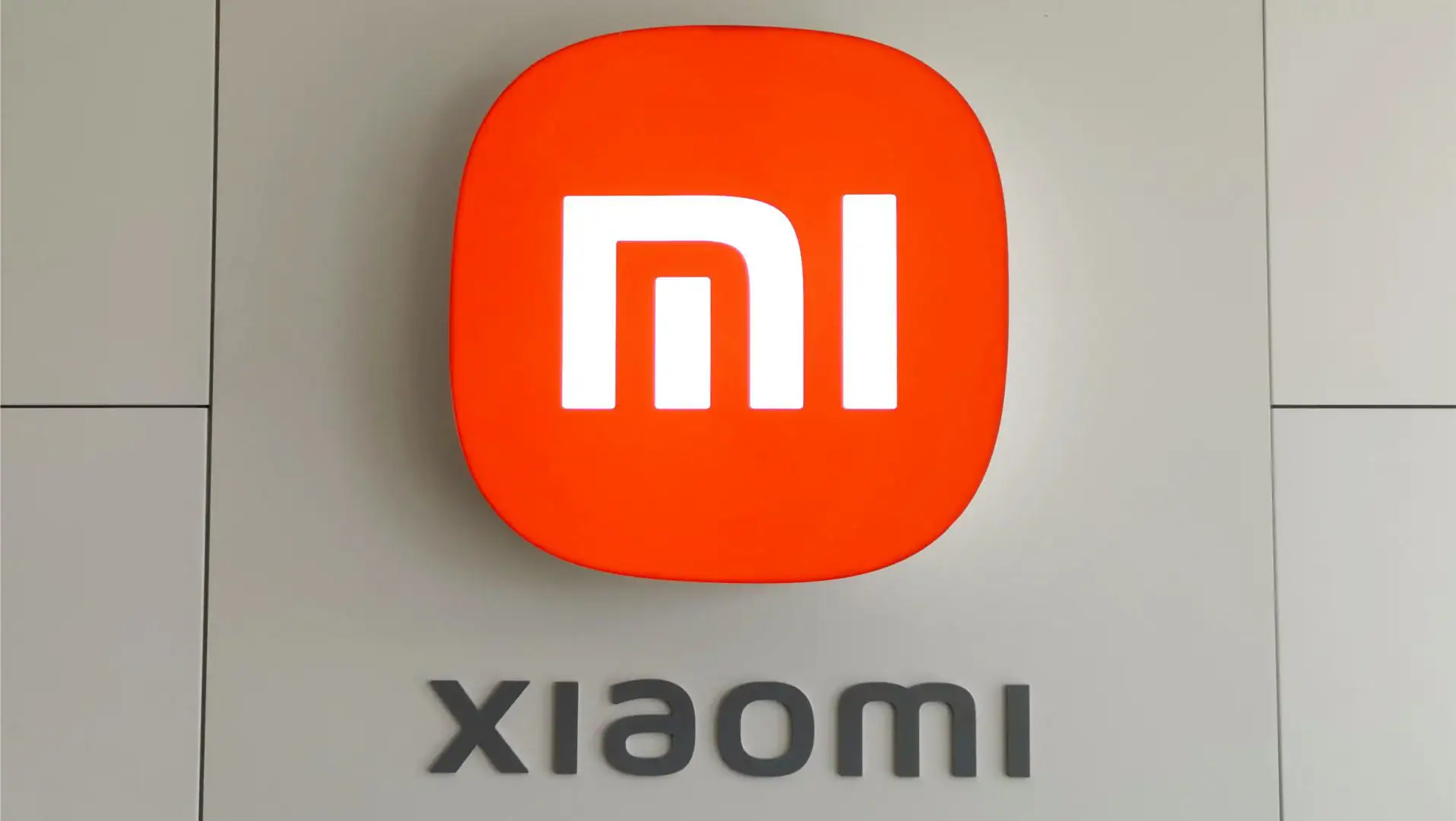 Logo Xiaomi, marque technologique innovante, sur un mur blanc.